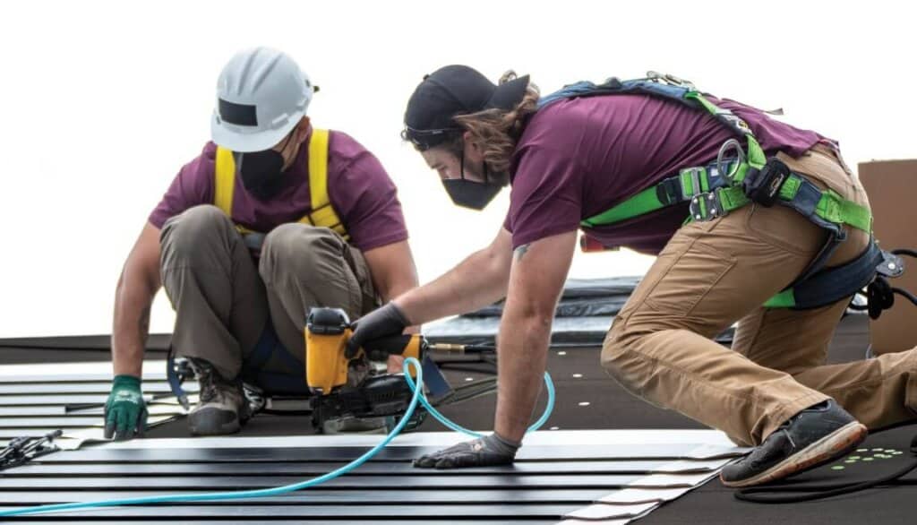 Installers putting up some solar roof shingles